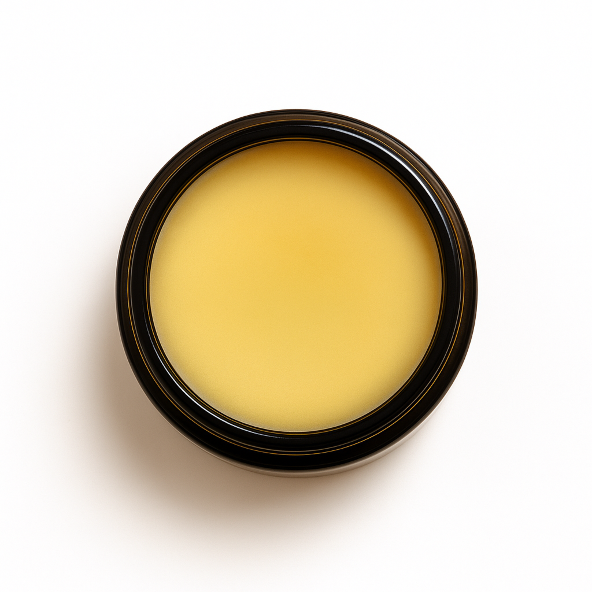 Top-down view of an open amber glass jar filled with solid light yellow tallow balm. Balancing Tallow Balm formulated for sensitive skin and moisture barrier support.