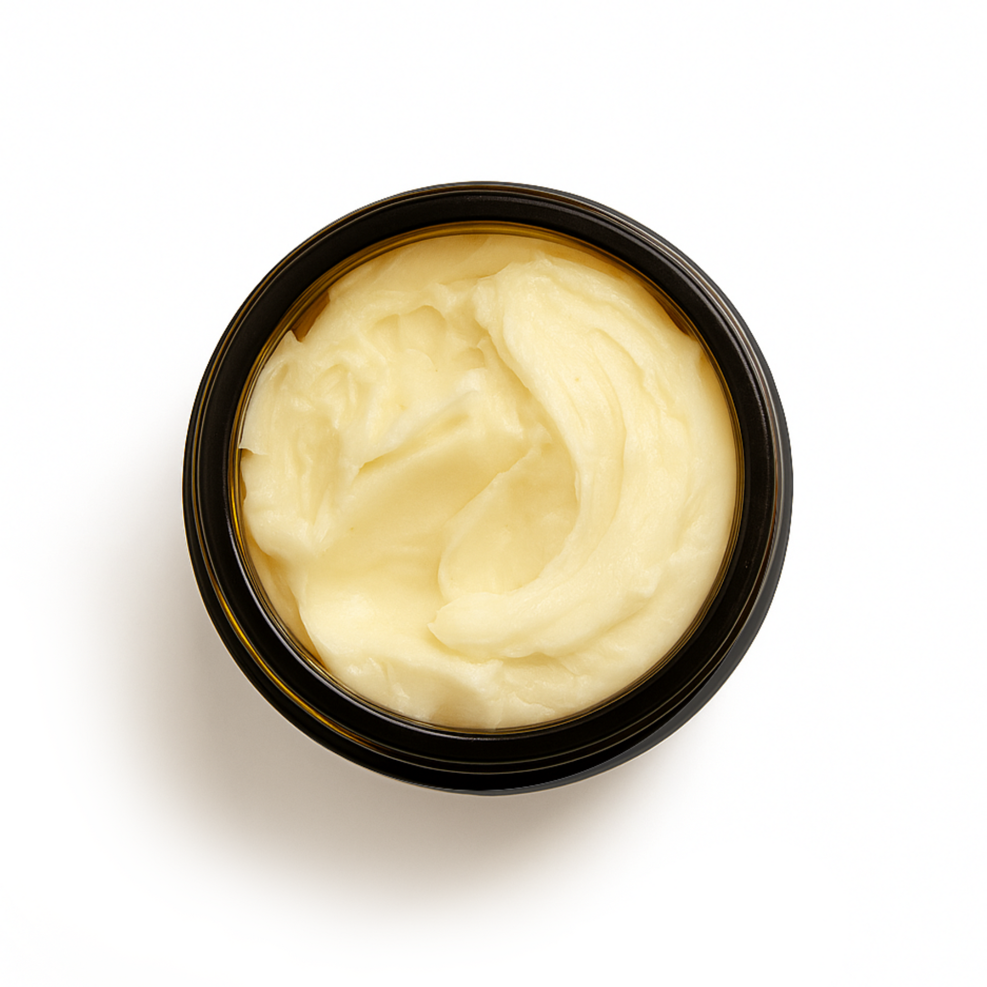 Top-down view of an open amber glass jar filled with creamy, whipped tallow balm. Ideal for nourishing and balancing sensitive skin with natural ingredients.