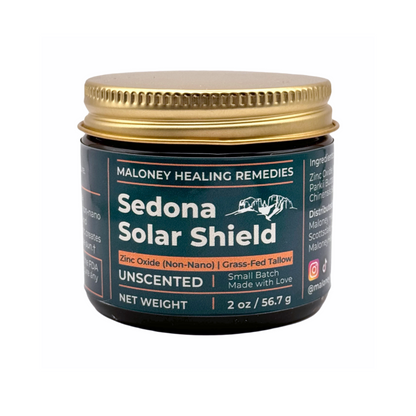 Amber glass jar of Sedona Solar Shield by Maloney Healing Remedies with gold metal lid, labeled as an unscented tallow-based balm with non-nano zinc oxide.