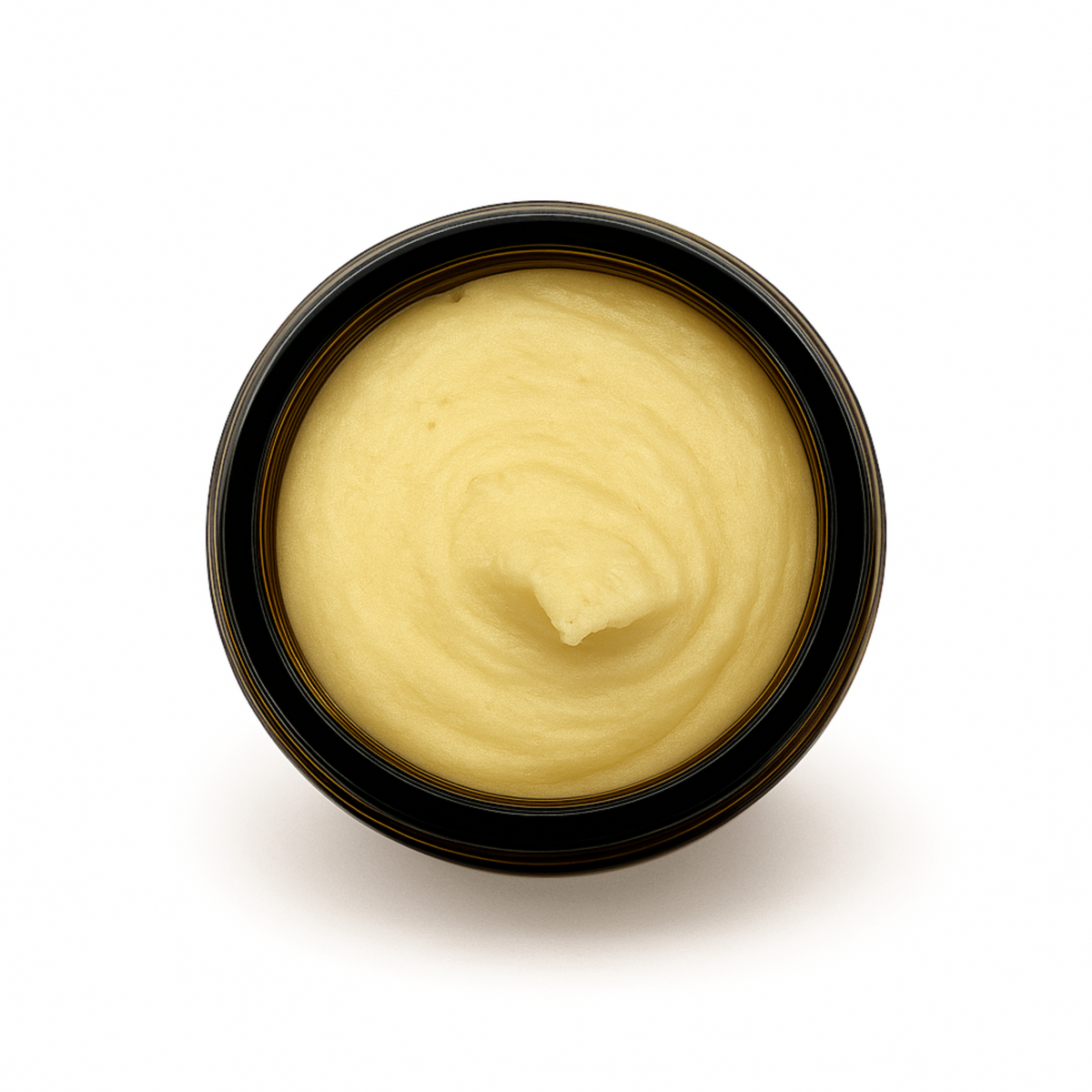 Top-down view of an open amber jar filled with whipped honey tallow balm for face & body, showing its smooth, creamy texture.